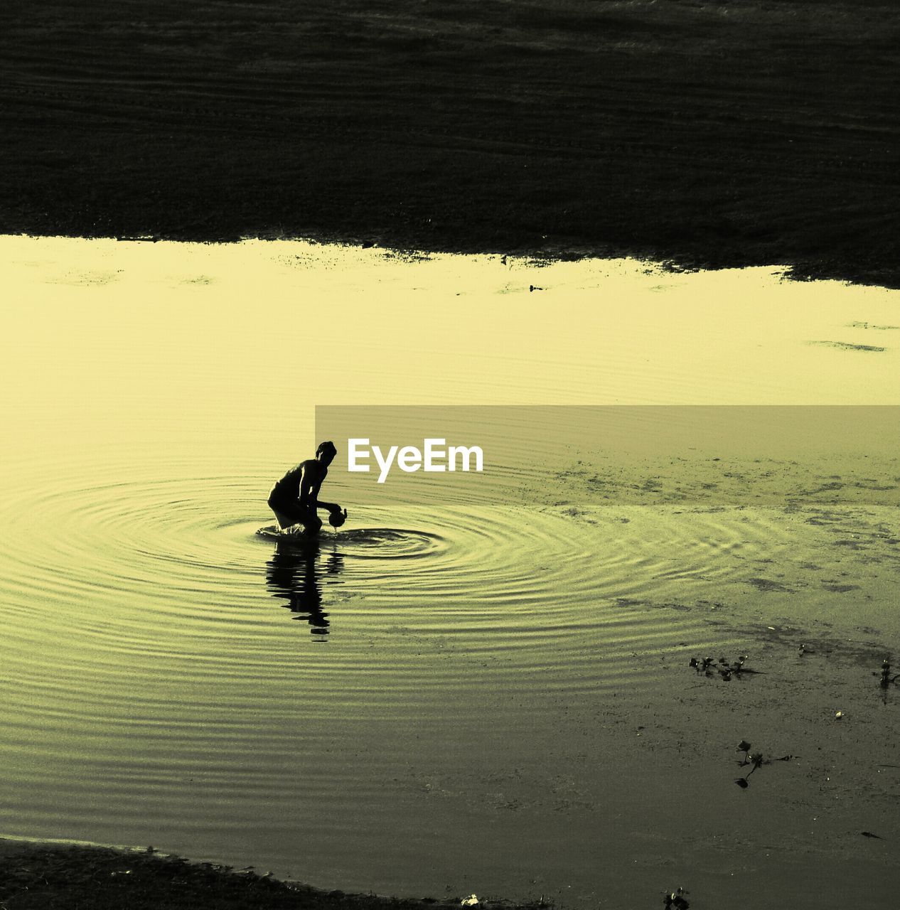 HIGH ANGLE VIEW OF MAN WITH SURFBOARD IN SEA