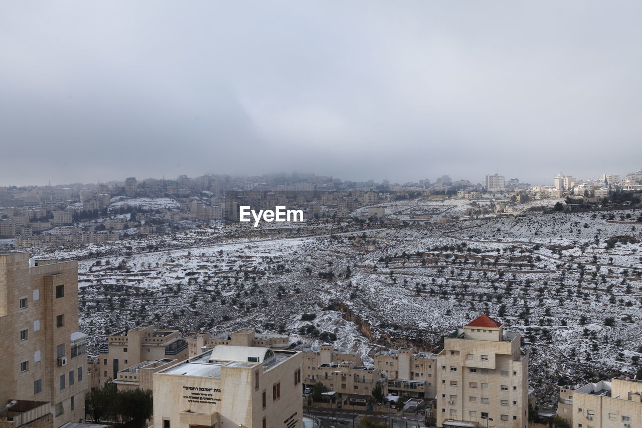 architecture, building exterior, built structure, city, building, cityscape, sky, winter, snow, residential district, nature, town, urban area, high angle view, no people, house, cold temperature, travel destinations, landscape, environment, outdoors, skyline, roof, cloud, residential area, aerial photography, travel, day, fog, community, tourism