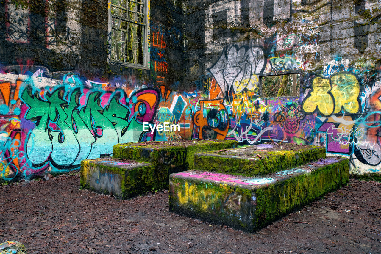 GRAFFITI ON WALL BY TREES