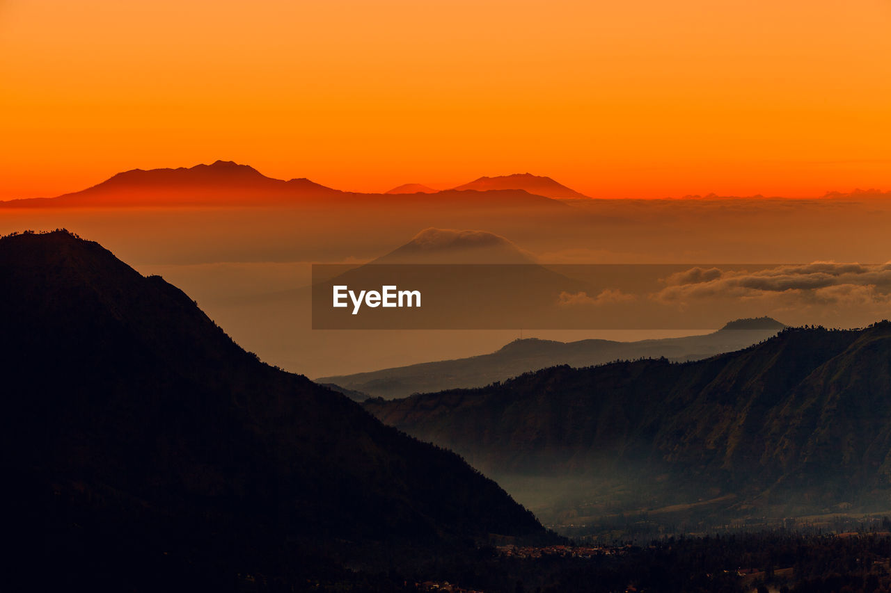 Scenic view of silhouette mountains against sky during sunset