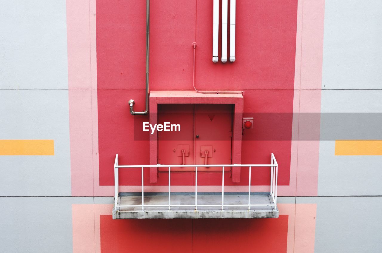 Closed red door and balcony of building