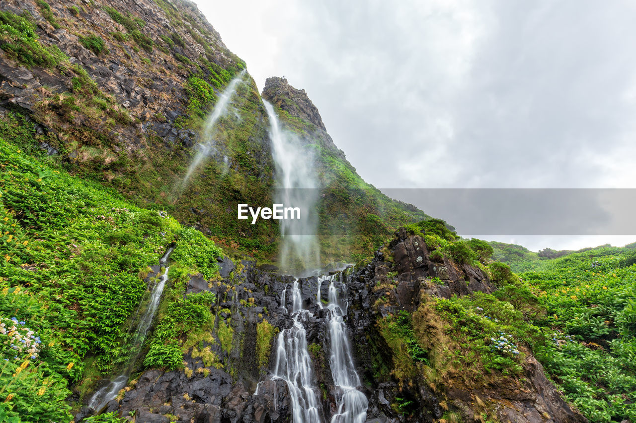 Scenic view of waterfall against sky