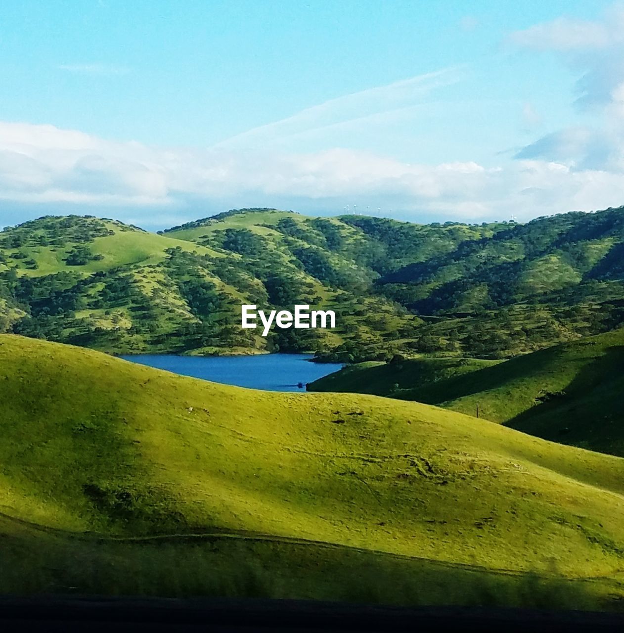 SCENIC VIEW OF GREEN LANDSCAPE AND MOUNTAINS AGAINST SKY