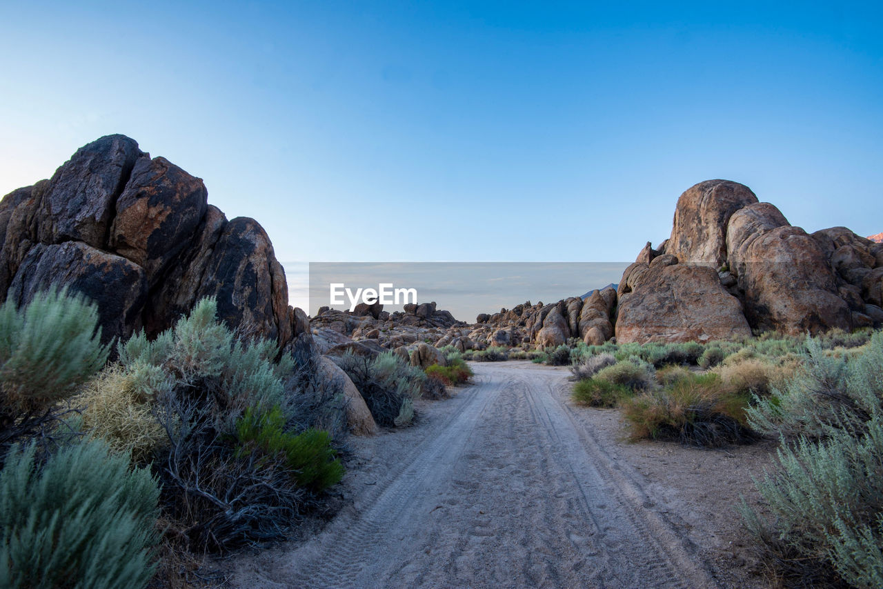 Road amidst rocks against clear sky