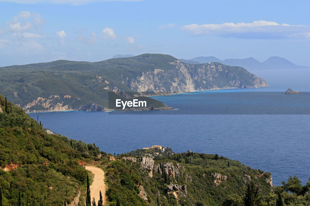 Scenic view of sea and mountains against sky