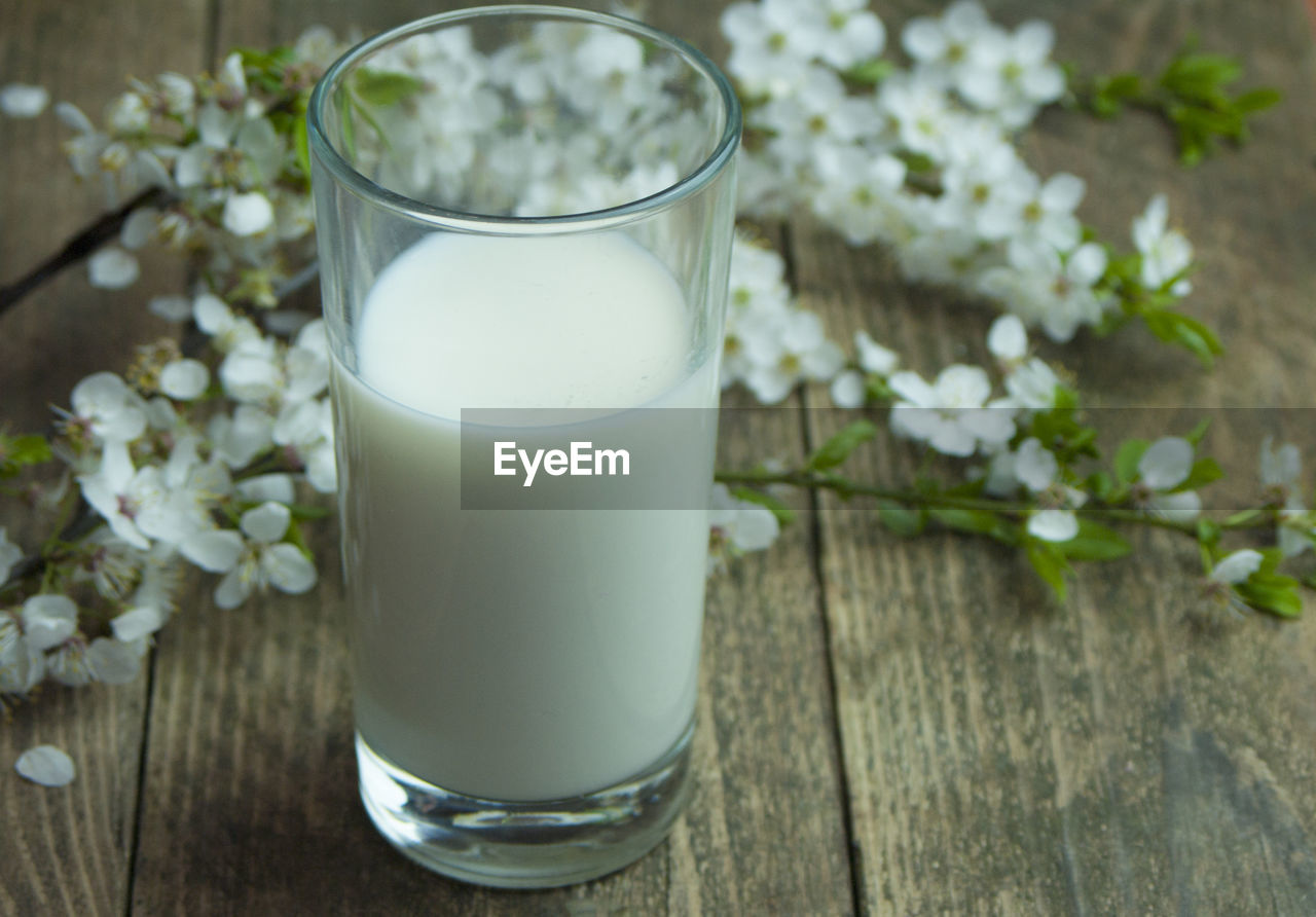 CLOSE-UP OF WHITE AND DRINK ON GLASS TABLE