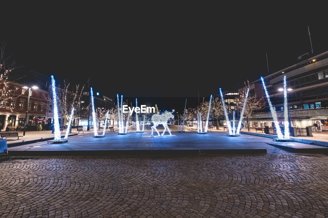 ILLUMINATED LIGHT TRAILS ON STREET AT NIGHT