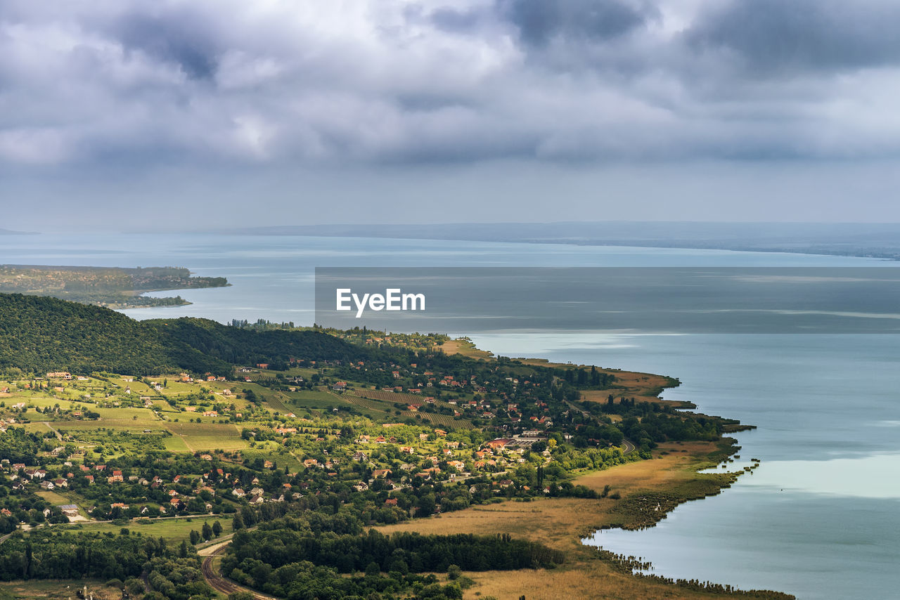 Scenic view of coastline against cloudy sky