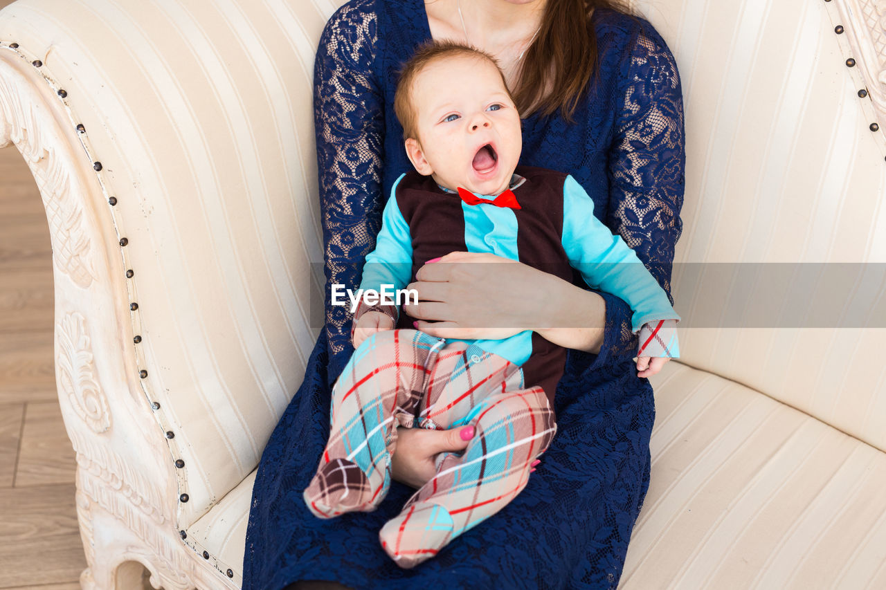 FULL LENGTH OF CUTE BABY LYING ON BED