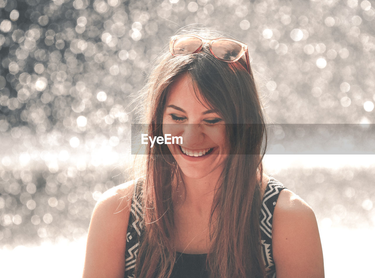 Smiling young woman with long hair standing outdoors