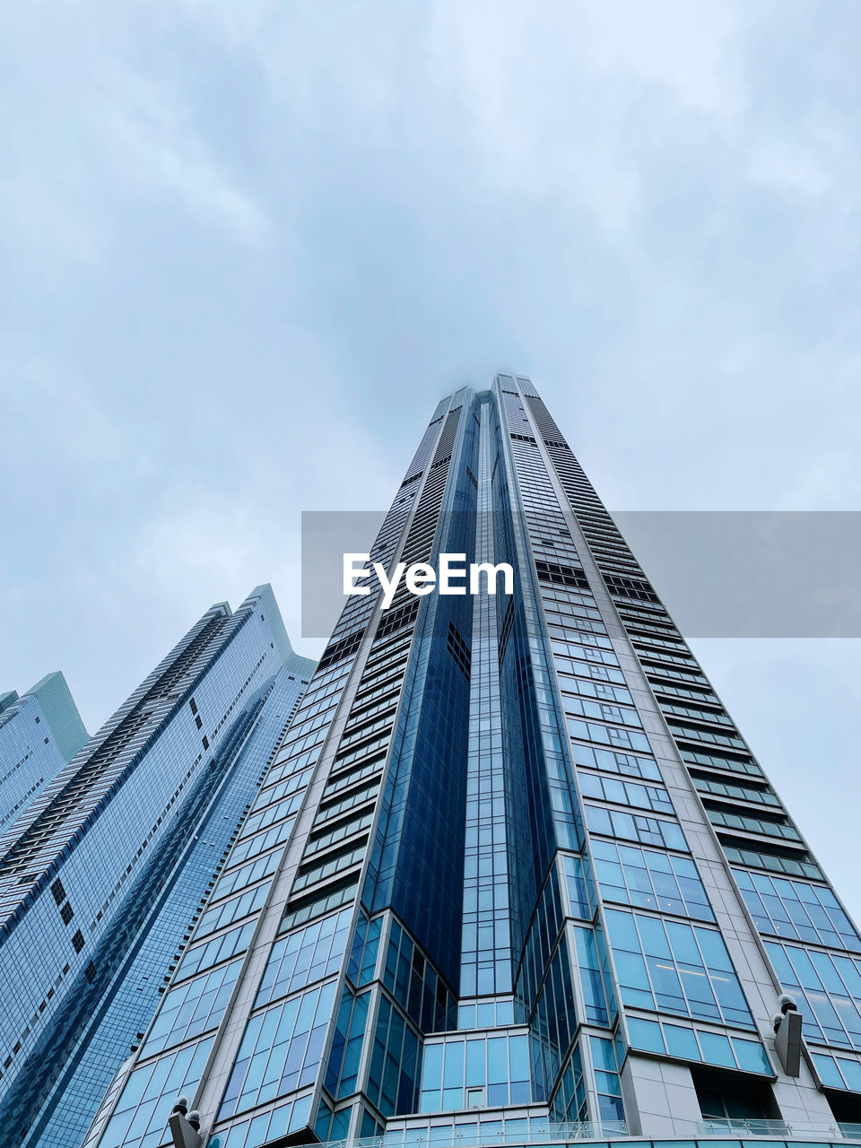 LOW ANGLE VIEW OF MODERN BUILDINGS AGAINST CLOUDY SKY