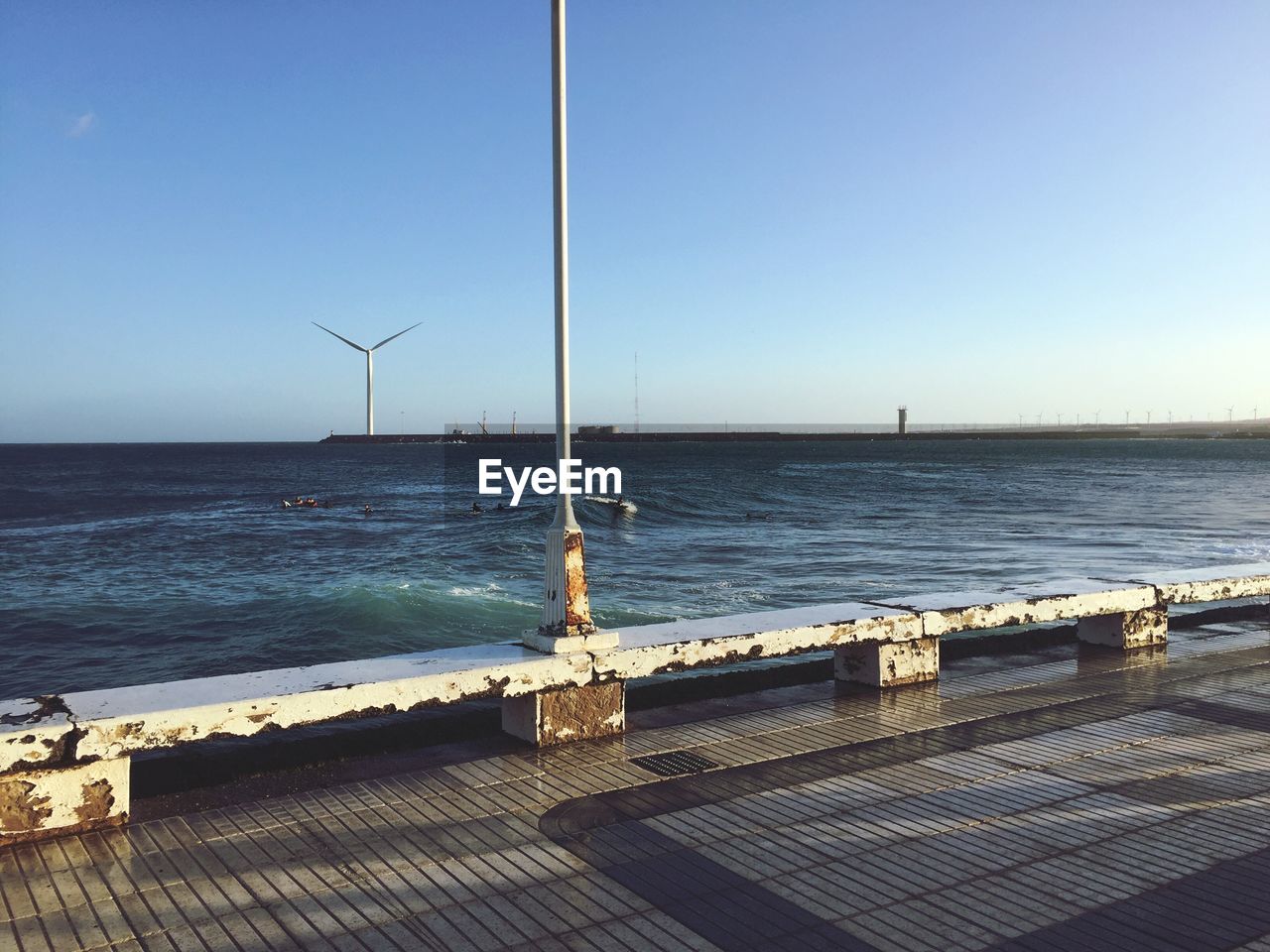 WIND TURBINES ON SEA AGAINST CLEAR BLUE SKY