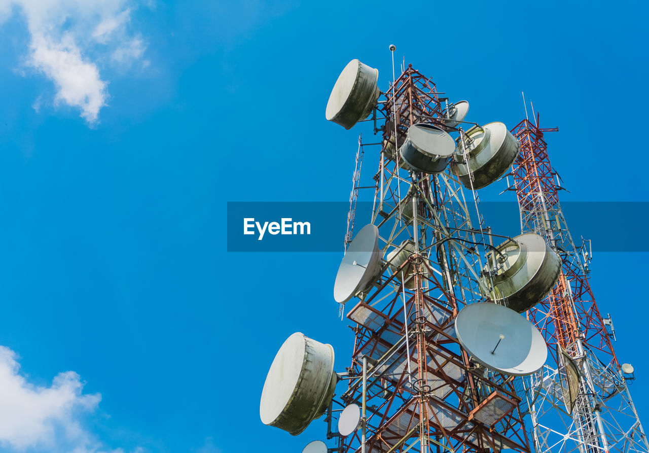 Low angle view of communications tower against blue sky