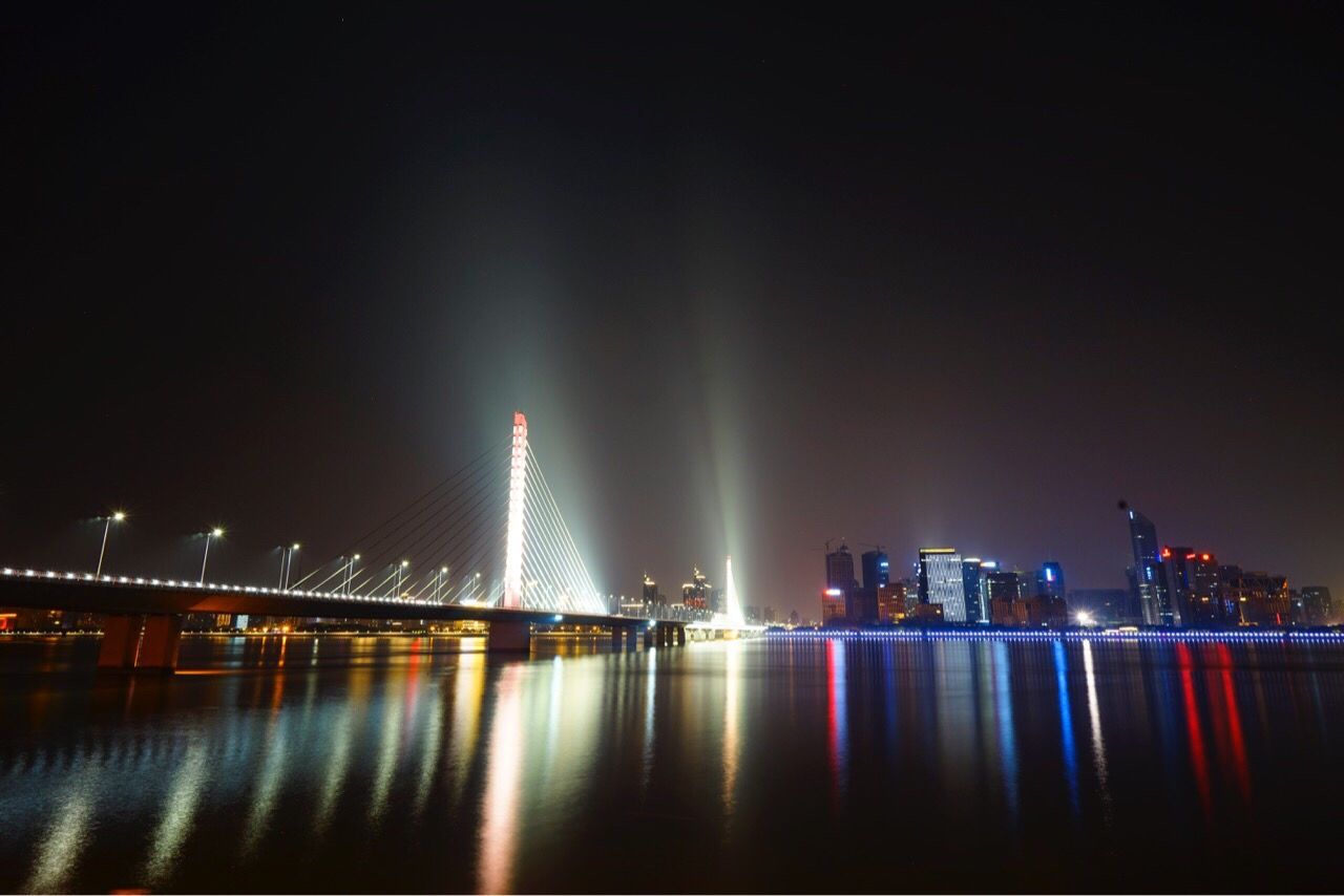 SUSPENSION BRIDGE OVER RIVER AT NIGHT