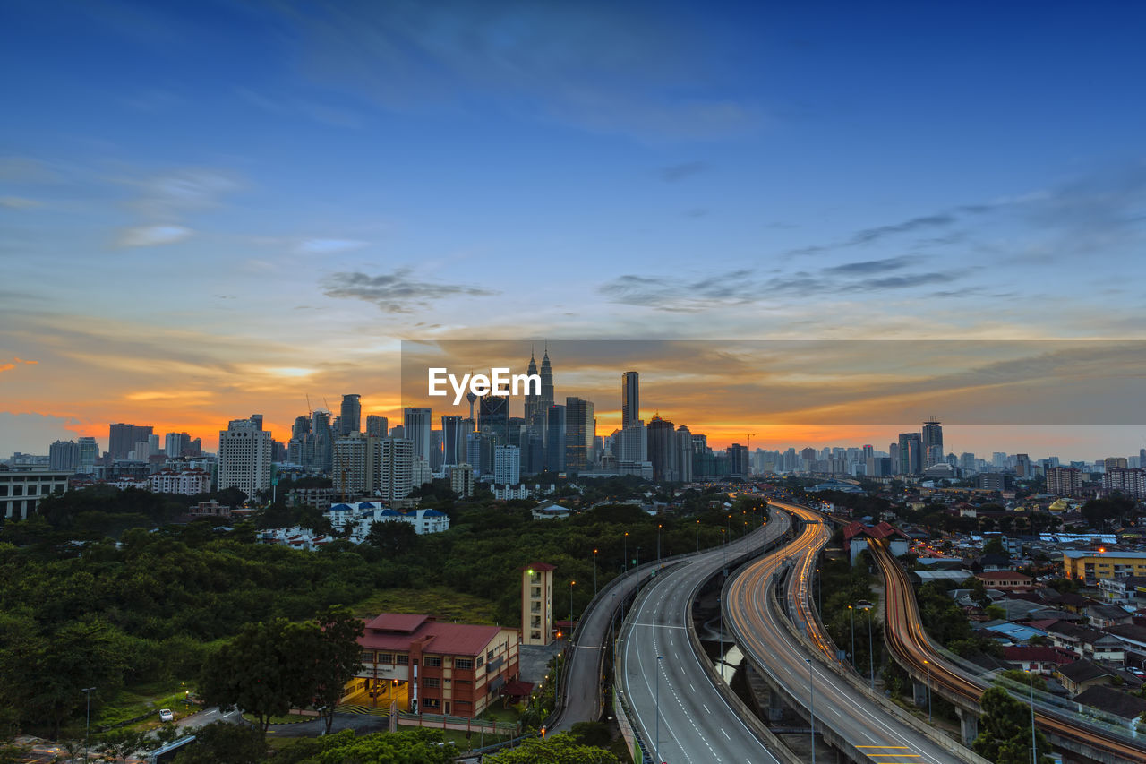 Aerial view of buildings in city against sky during sunset