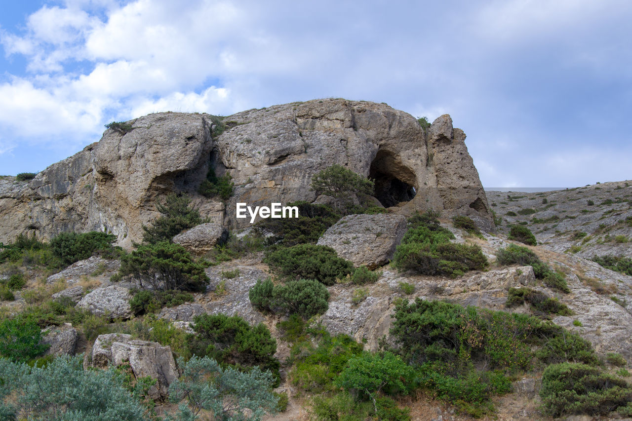 Low angle view of rocks on mountain against sky