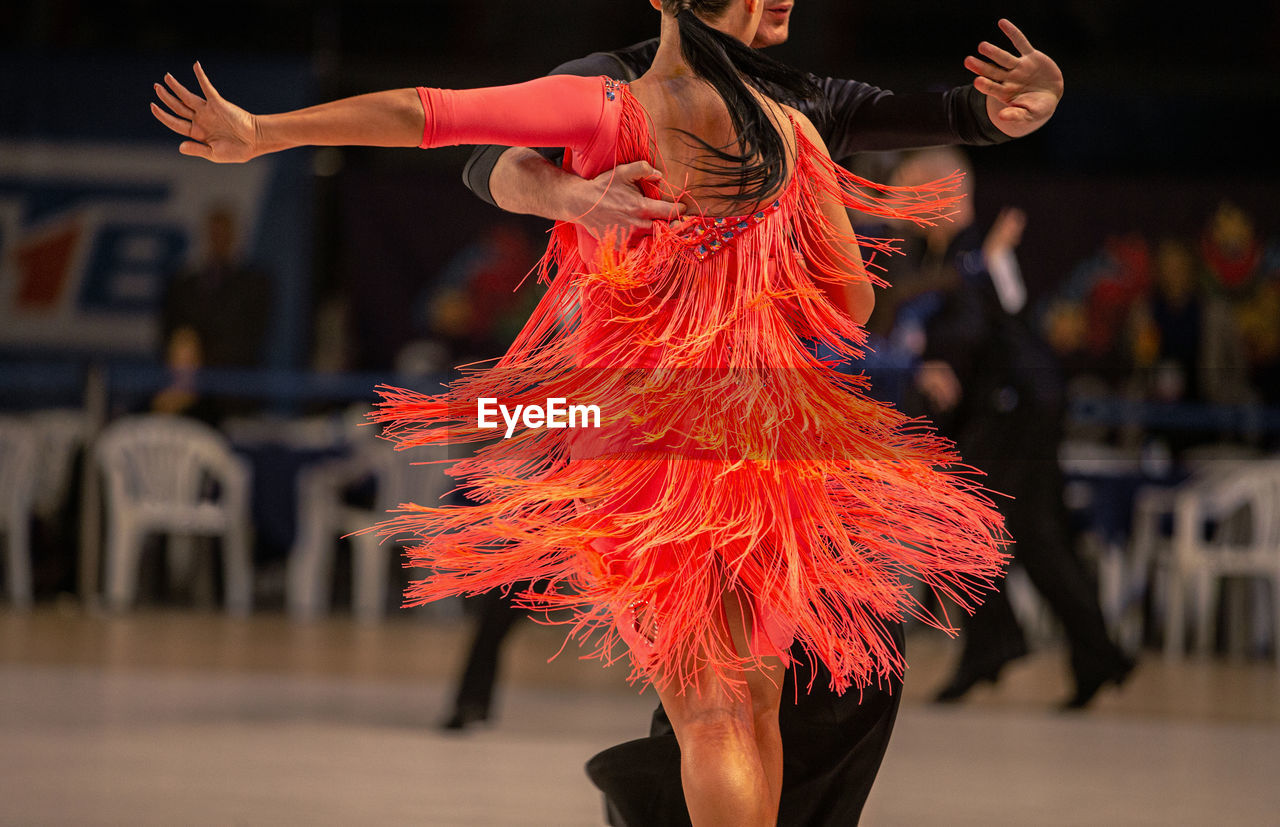 MIDSECTION OF WOMAN DANCING IN TRADITIONAL CLOTHING