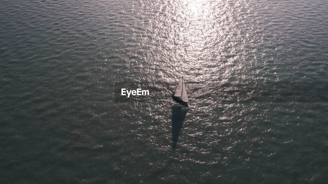 HIGH ANGLE VIEW OF MAN STANDING IN WATER