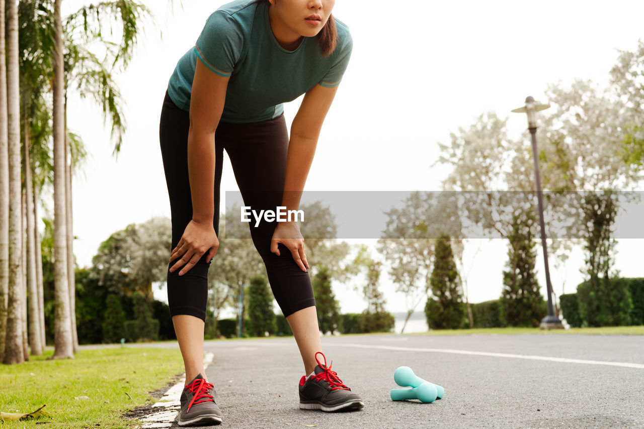 Tired fitness woman taking a rest after training hard on the par