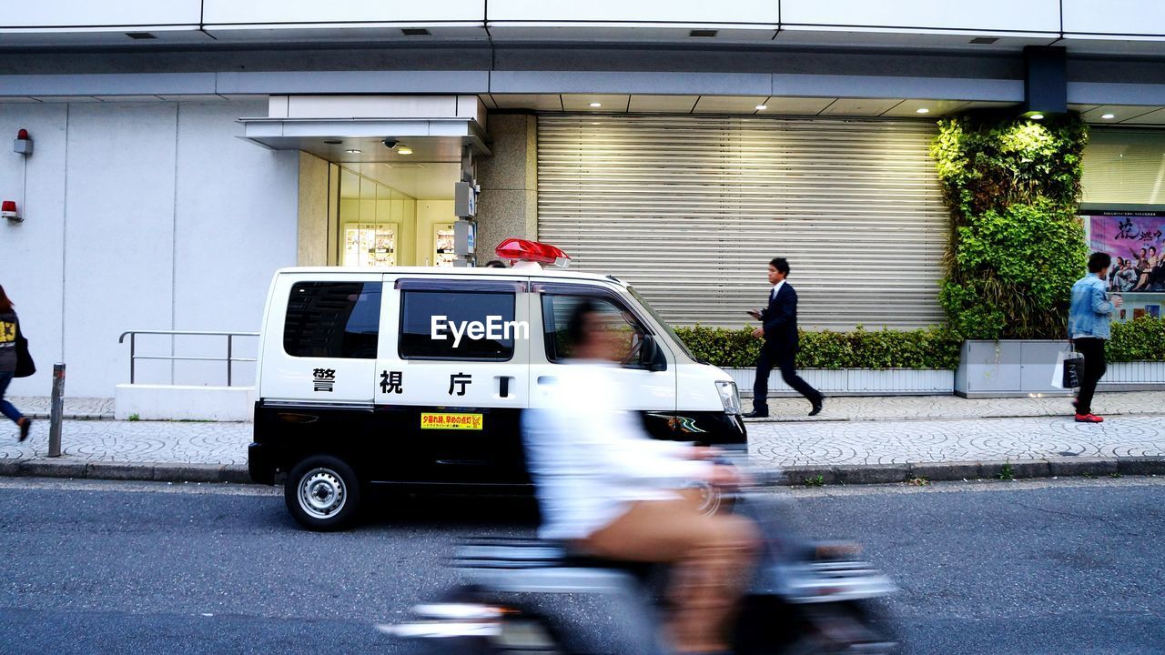 BLURRED MOTION OF PEOPLE ON ROAD