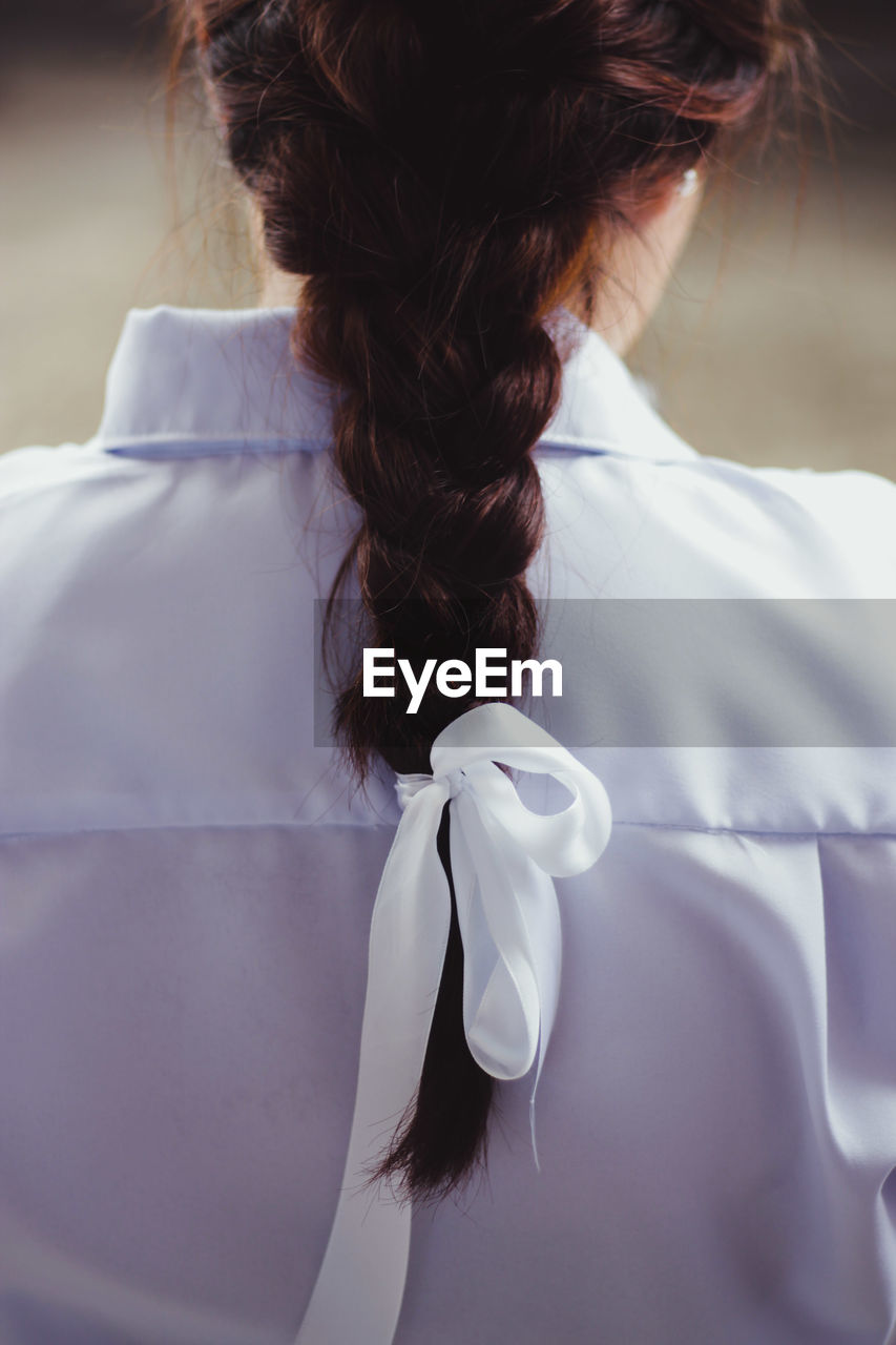 Rear view of woman hair tied with ribbon