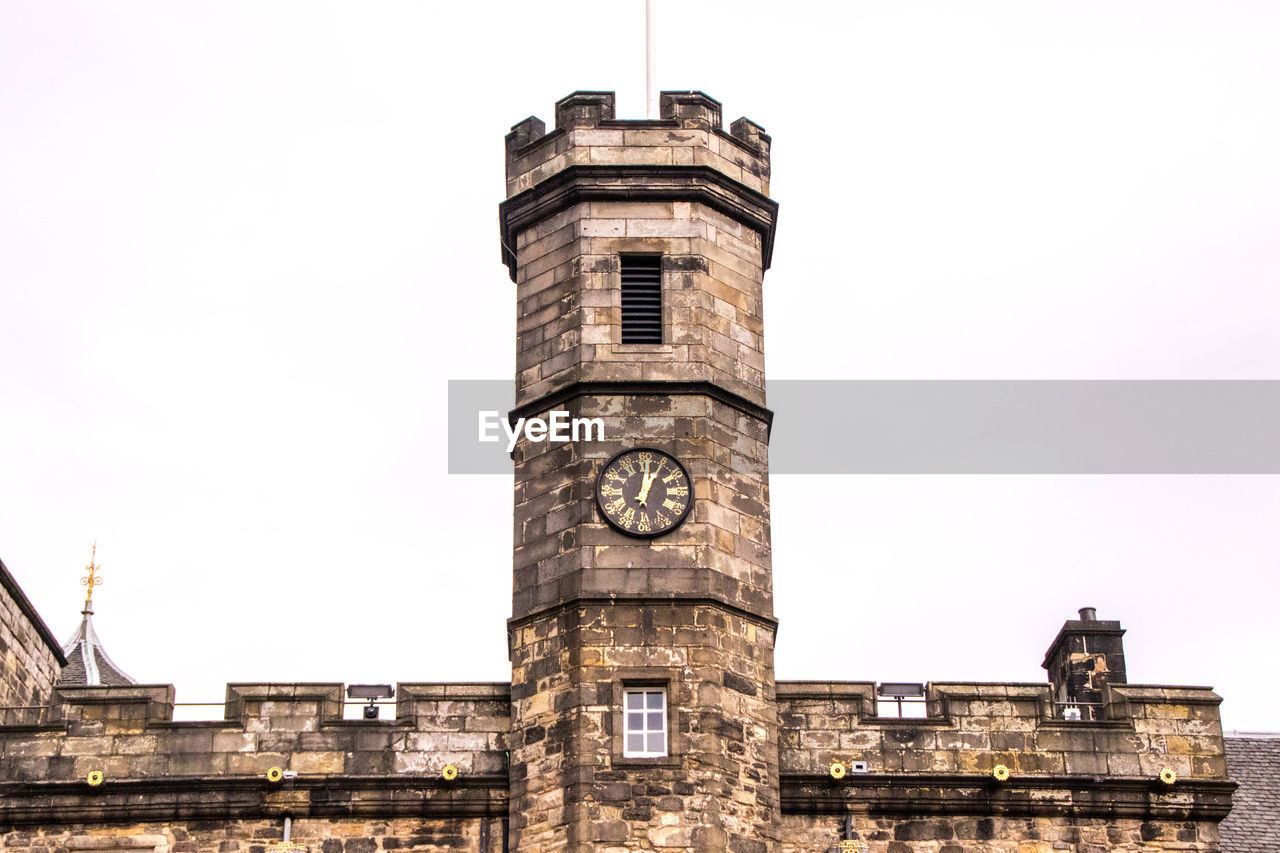 LOW ANGLE VIEW OF CLOCK TOWER AGAINST BUILDING