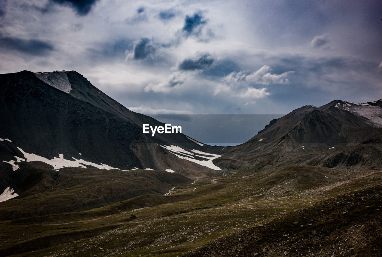 Scenic view of mountains against cloudy sky