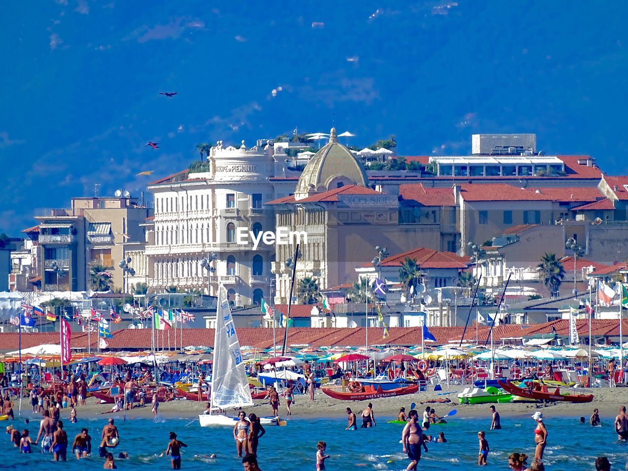 People enjoying summer in sea against buildings