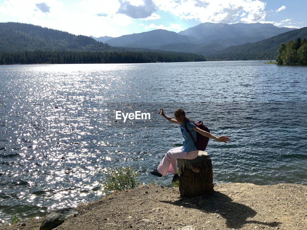 Woman sitting by lake