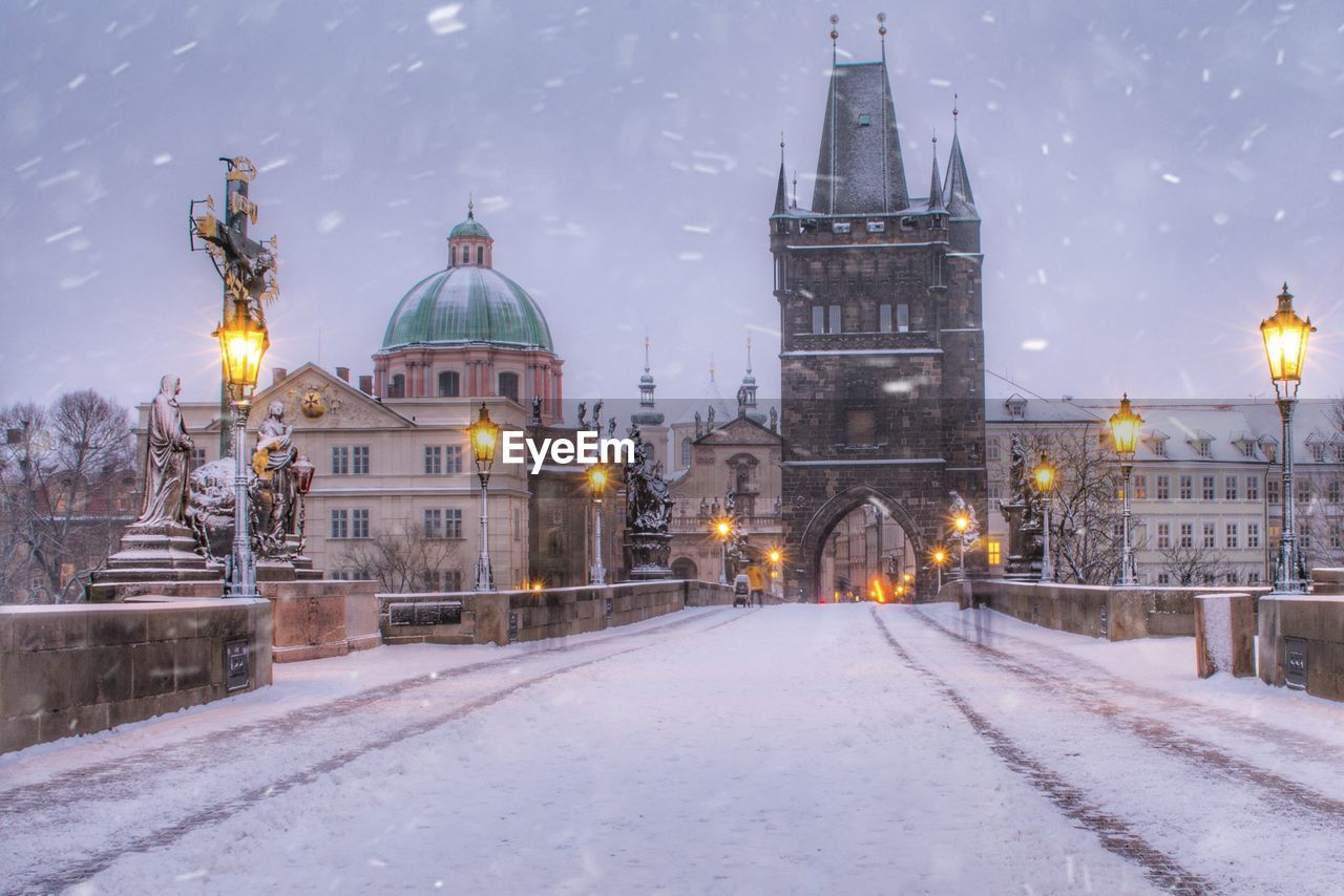 View of illuminated buildings in city during winter