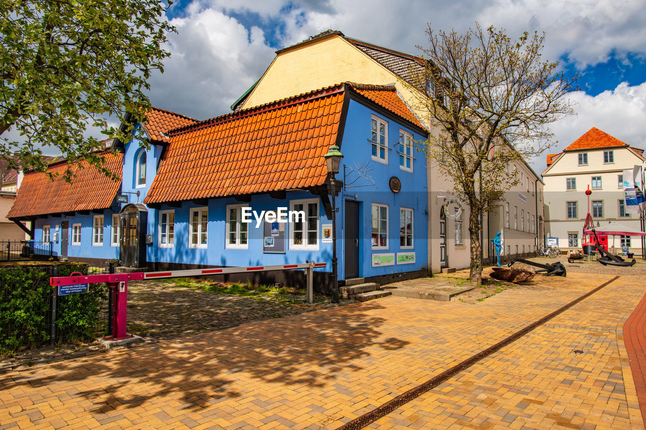 HOUSES BY BUILDING AGAINST SKY