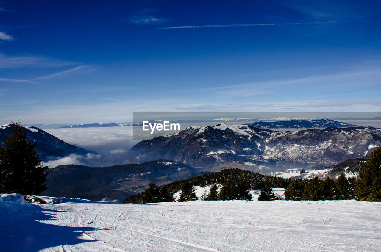 Scenic view of mountains against blue sky