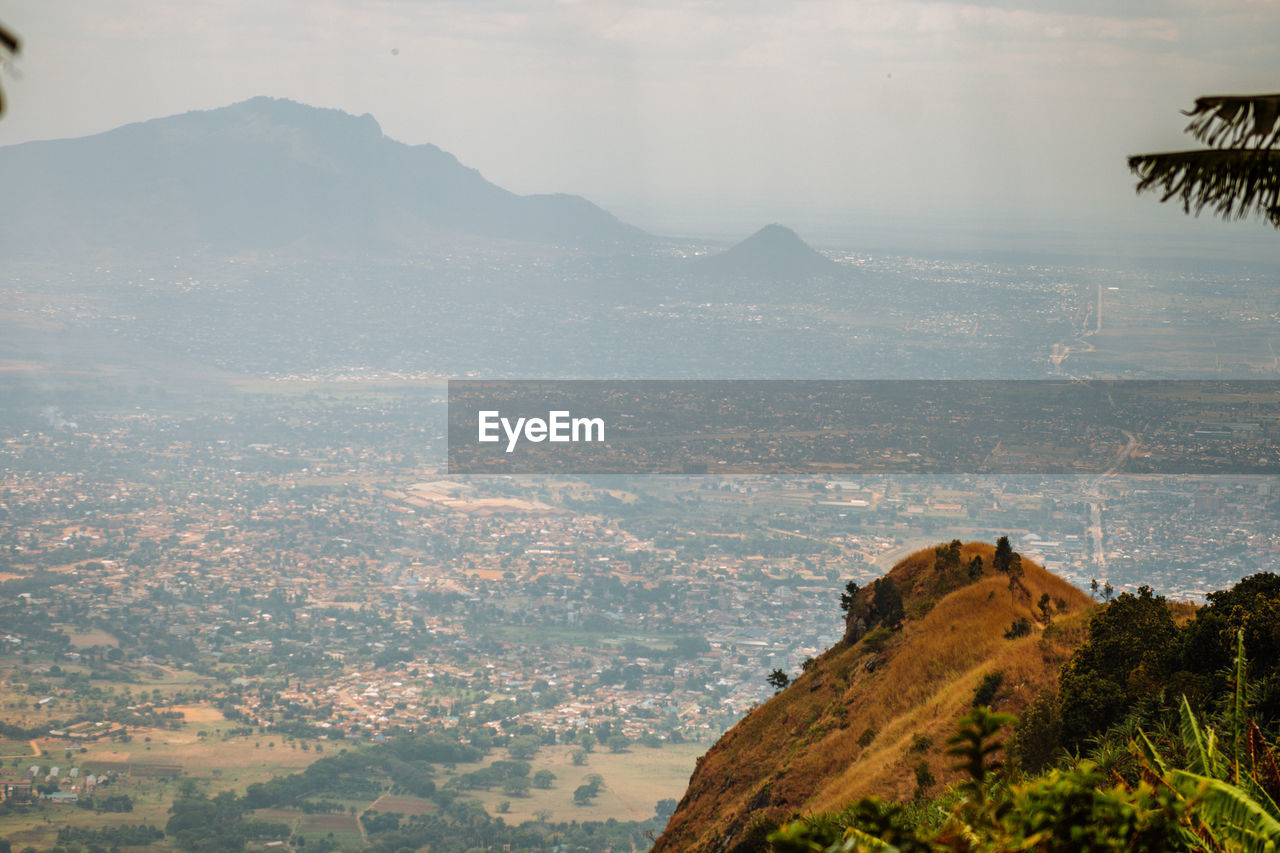 AERIAL VIEW OF LANDSCAPE AND MOUNTAINS AGAINST SKY