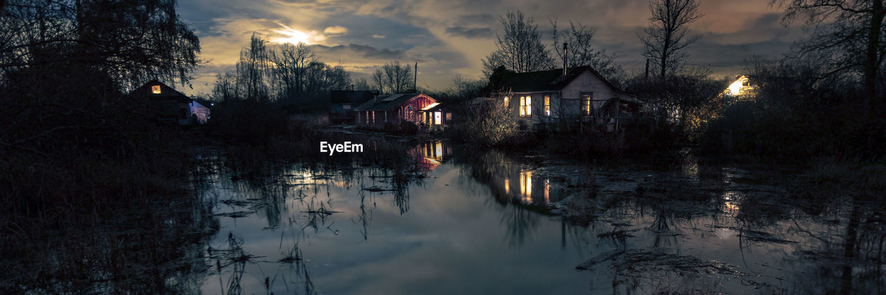 Canal amidst buildings against sky at dusk