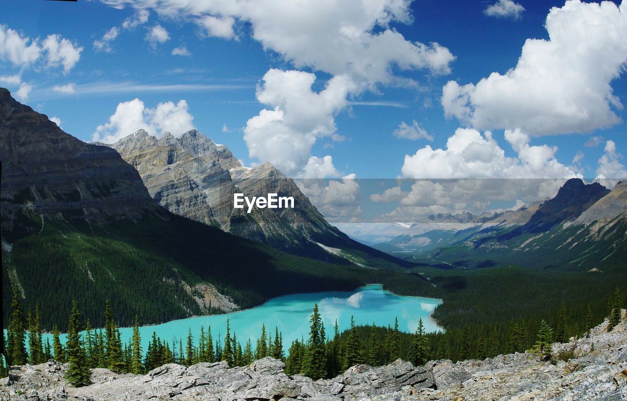 Scenic view of lake by mountains against cloudy sky