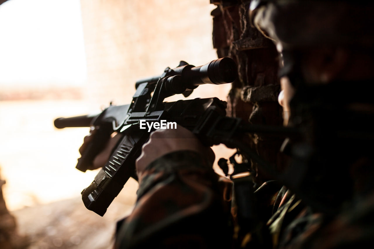 Soldier in war, with weapons in his hands, aim at the enemy