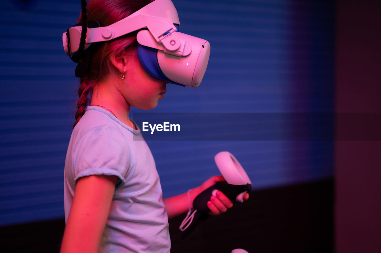 Vr game and virtual reality. kid girl gamer eight years old fun playing on futuristic video game