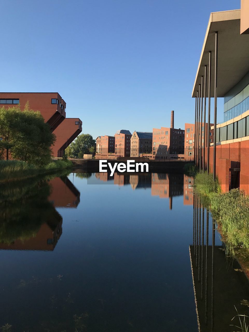 REFLECTION OF BUILDINGS ON LAKE AGAINST CLEAR SKY