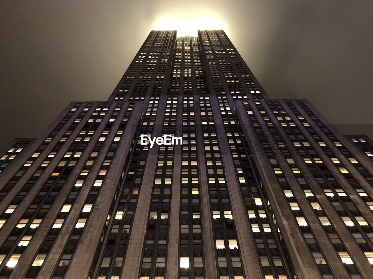 LOW ANGLE VIEW OF ILLUMINATED BUILDING AGAINST SKY