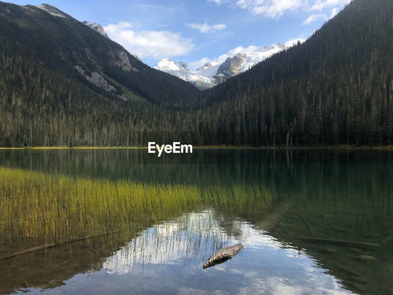 Scenic view of lake by mountains against sky