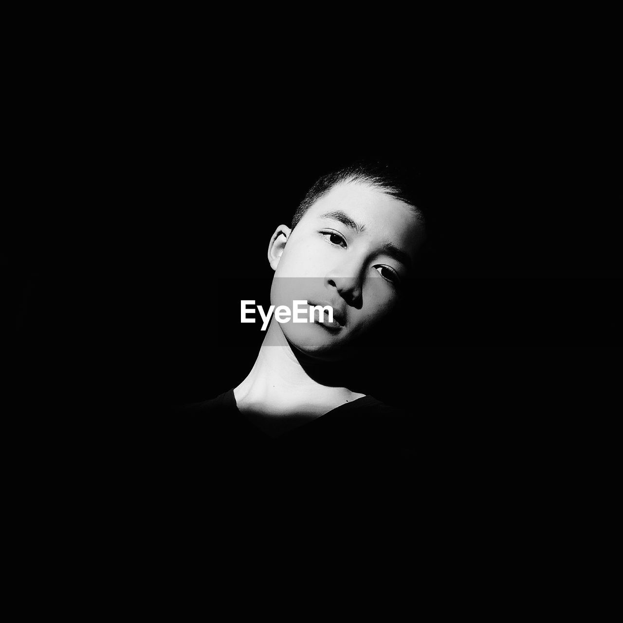 Portrait of boy against black background