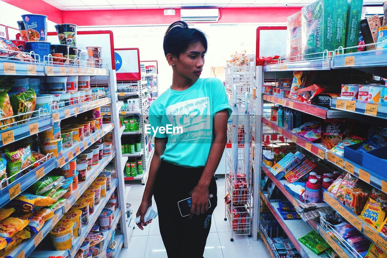 YOUNG WOMAN STANDING IN STORE