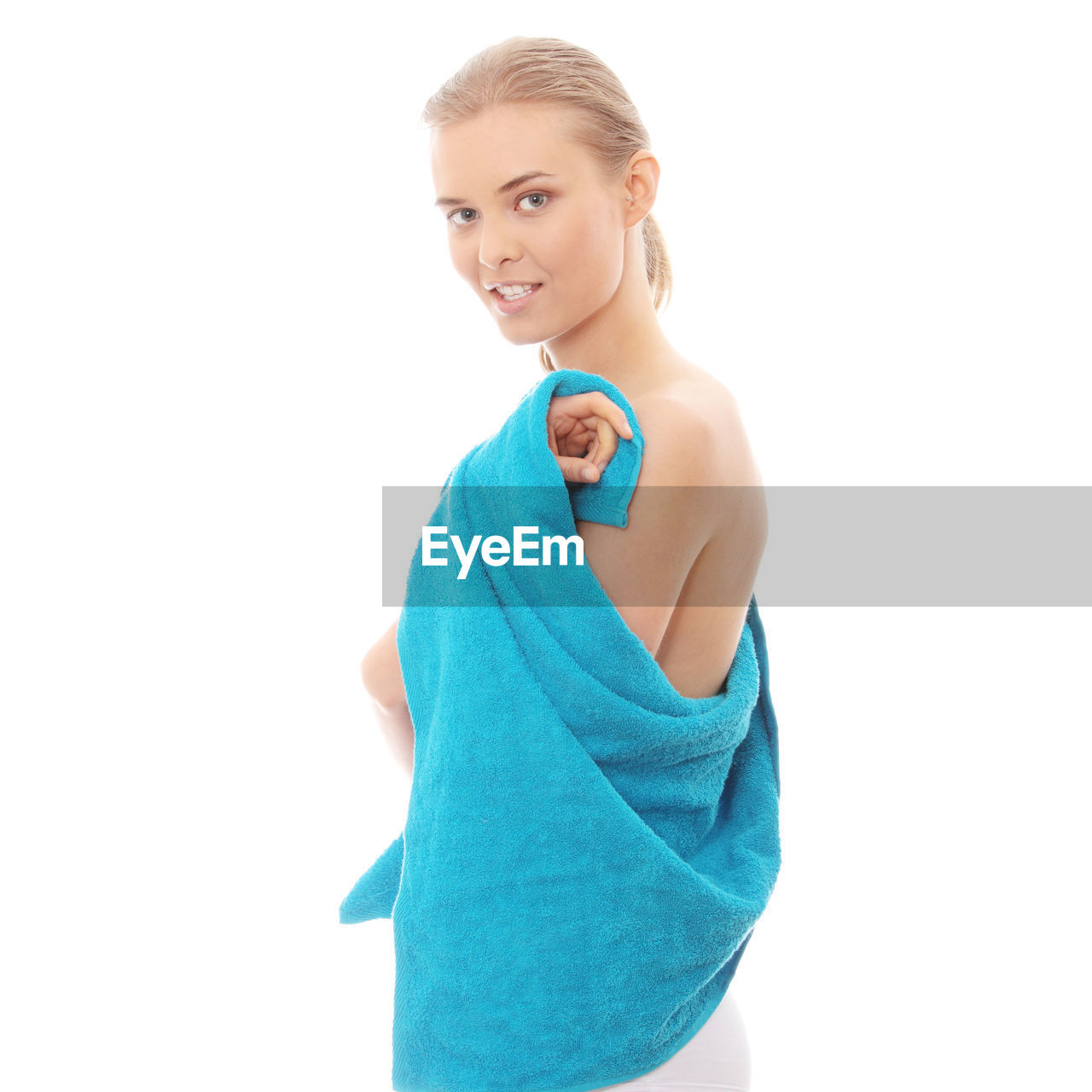 Shirtless woman with towel against white background