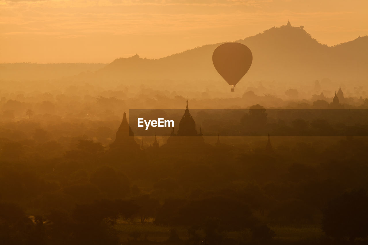 Silhouette hot air balloon flying during sunset