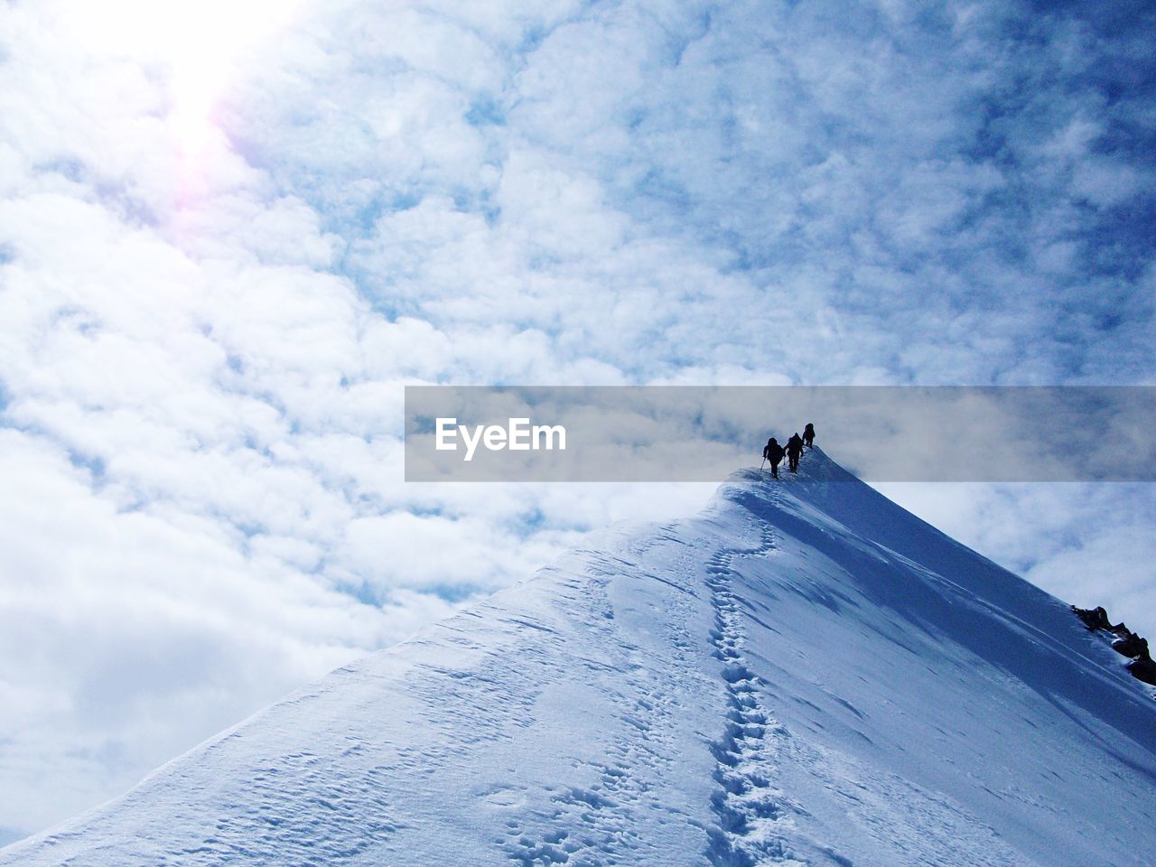 Low angle view of people hiking on mountain