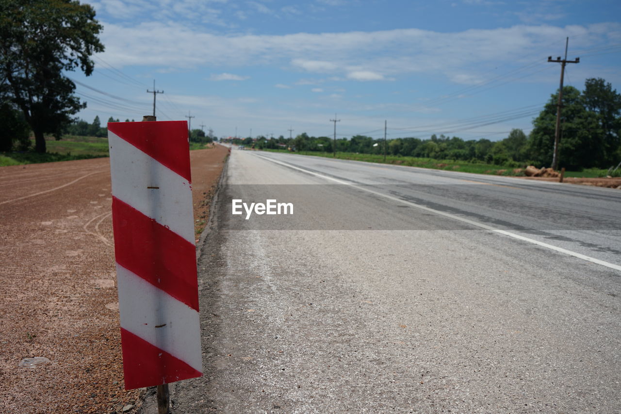 road, sign, transportation, sky, lane, nature, no people, road surface, cloud, communication, infrastructure, street, day, tree, asphalt, symbol, city, plant, road sign, red, outdoors, guidance, tarmac, highway, warning sign, road marking, architecture