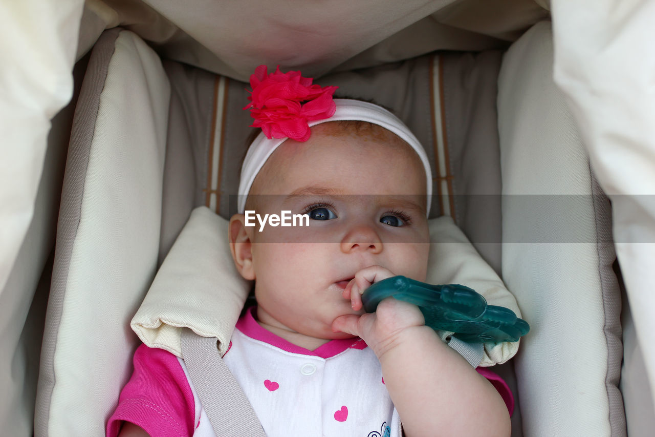 Close-up portrait of cute baby girl in carriage