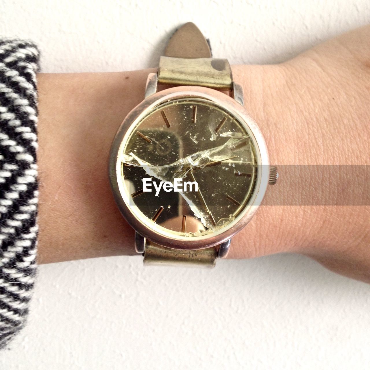 Cropped hand of woman wearing broken wristwatch