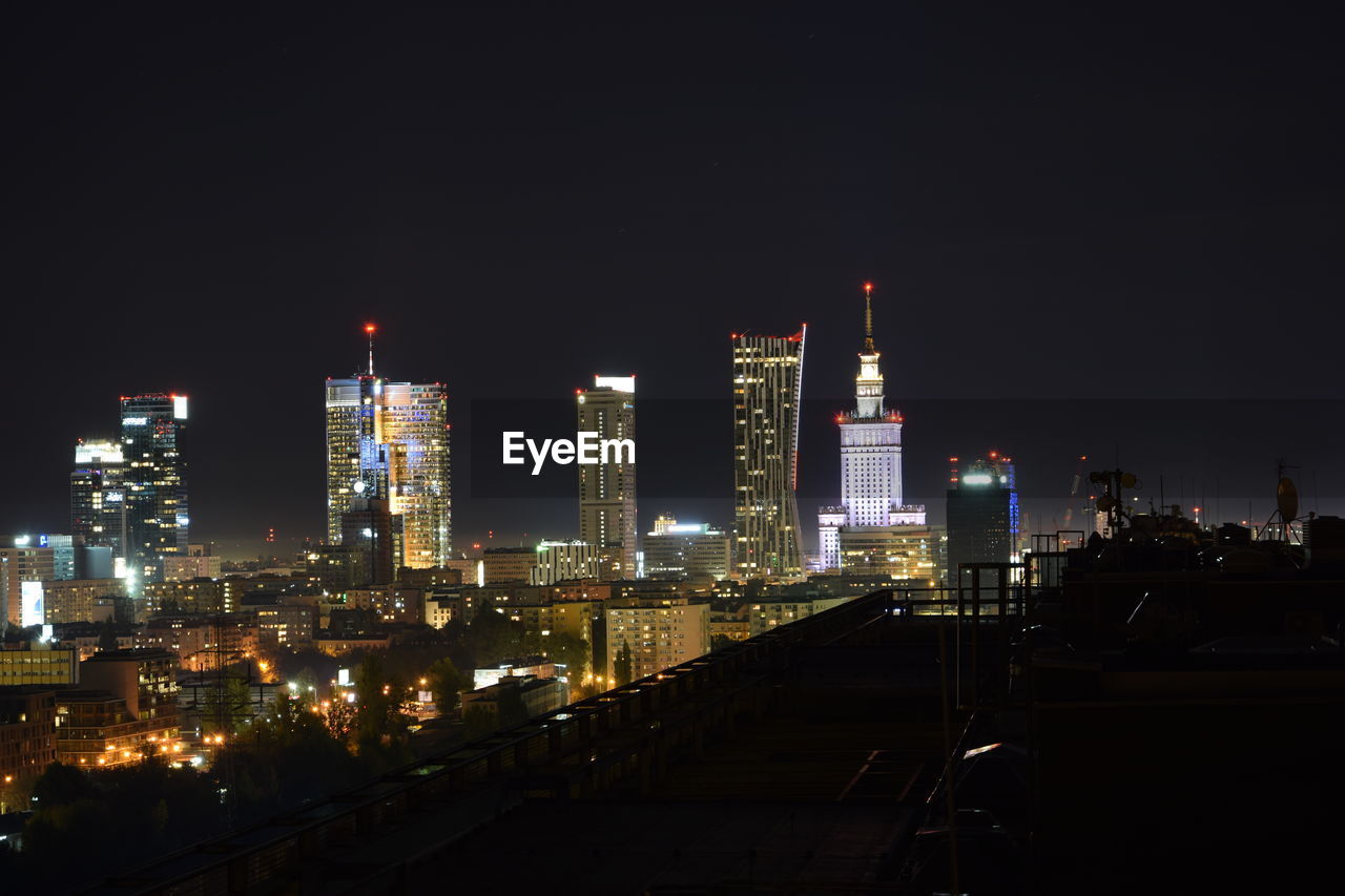 Illuminated city against sky at night