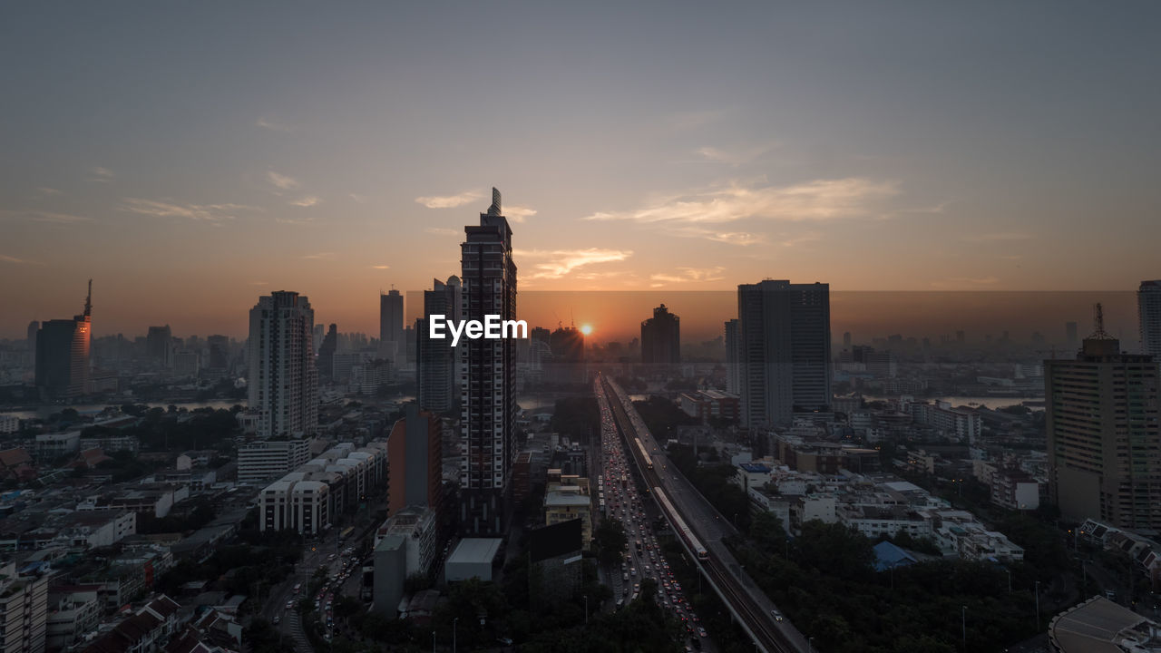 High angle view of building and vehicles in city at dusk